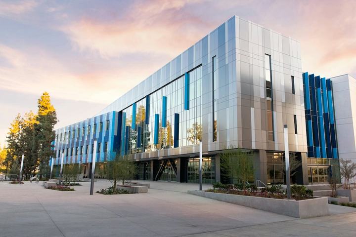 Modern three-story office building with a blue and silver facade