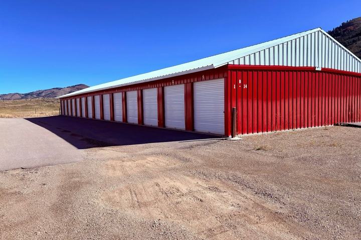Row of red self-storage units with white roll-up doors